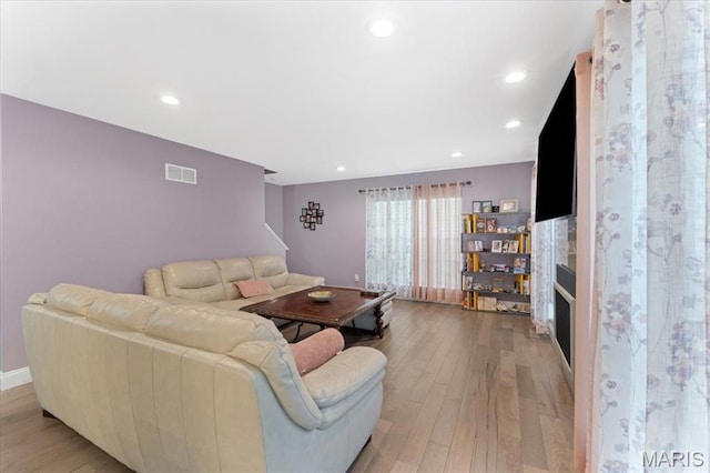 living room with light wood-style flooring, stairs, recessed lighting, and baseboards