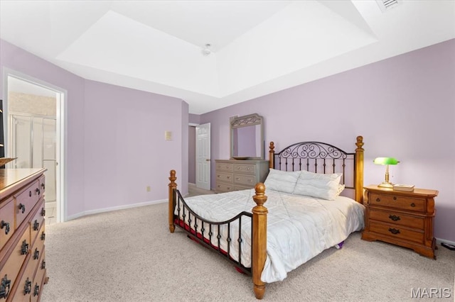 carpeted bedroom with ensuite bath and baseboards