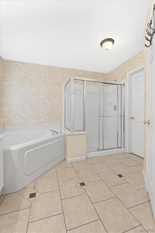 bathroom featuring tile patterned floors, a stall shower, and a garden tub