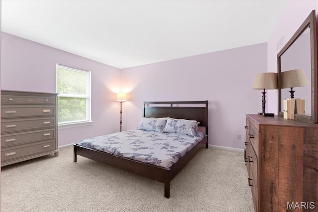 bedroom featuring light carpet and baseboards