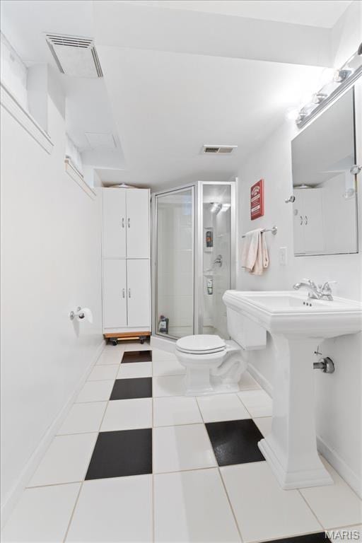 bathroom featuring a stall shower, toilet, and baseboards