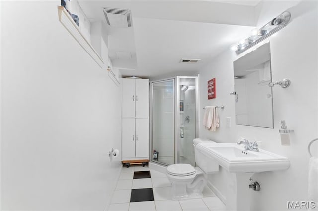 bathroom with a stall shower, toilet, tile patterned flooring, and baseboards