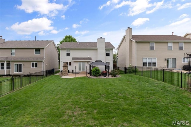 back of property with a gazebo, a patio, a yard, and a chimney