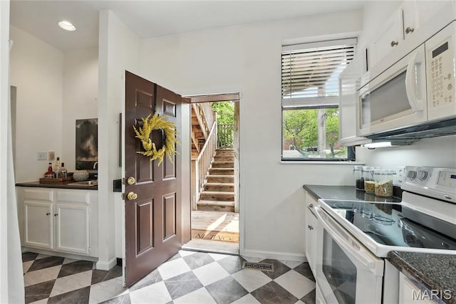 10 N Taylor Ave # 1S, Saint Louis, MO 63108 - kitchen featuring white appliances, dark countertops, white cabinetry, baseboards, and recessed lighting