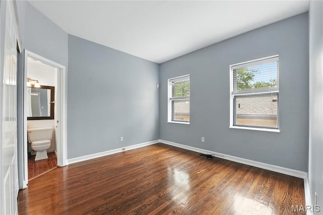 10 N Taylor Ave # 1S, Saint Louis, MO 63108 - unfurnished bedroom with dark wood-style flooring, baseboards, and ensuite bath
