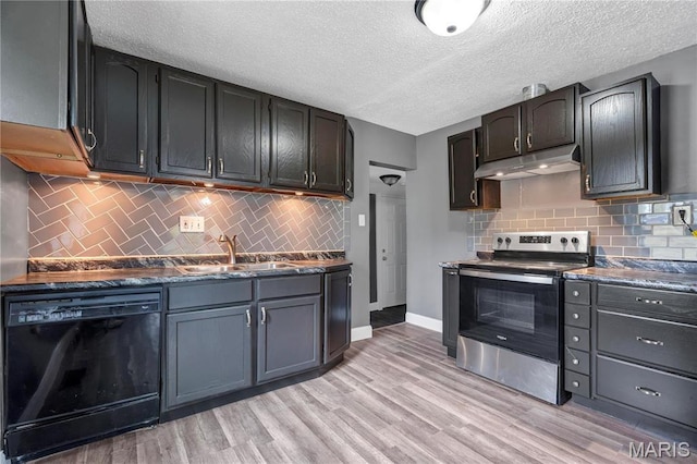 kitchen featuring dishwasher, electric stove, a sink, under cabinet range hood, and dark countertops