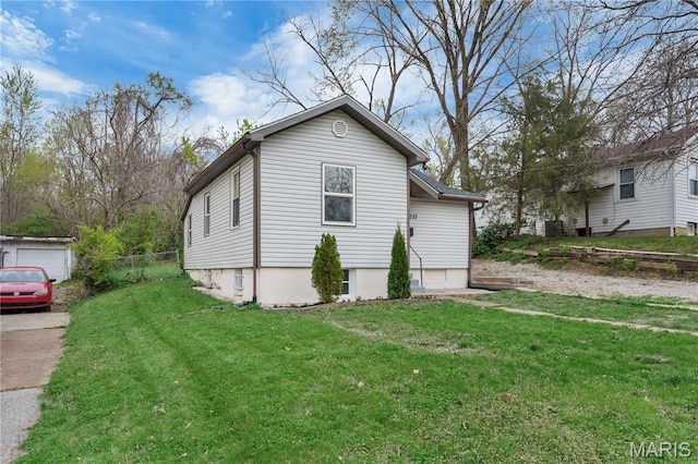 view of side of property featuring a yard and driveway