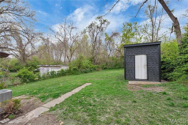 view of grassy yard featuring a shed, an outdoor structure, and cooling unit