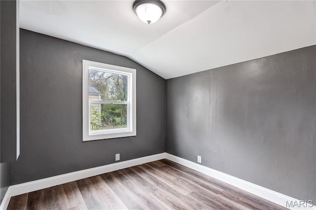 bonus room with vaulted ceiling, wood finished floors, and baseboards