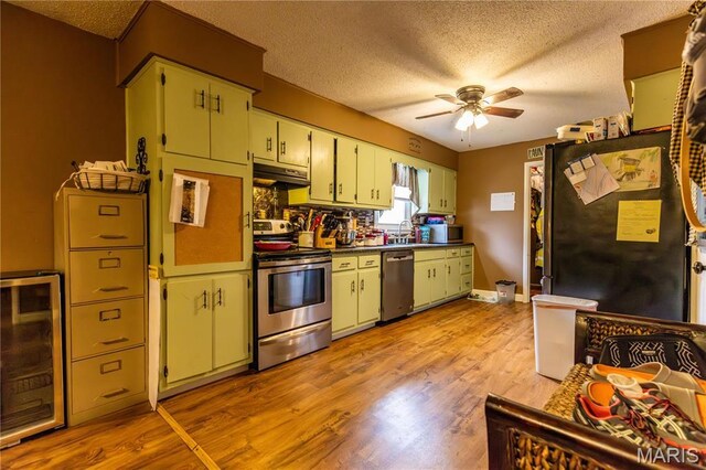 211 E Elm, Bertrand, MO 63823 - kitchen with appliances with stainless steel finishes, beverage cooler, a textured ceiling, a ceiling fan, and light wood-style floors