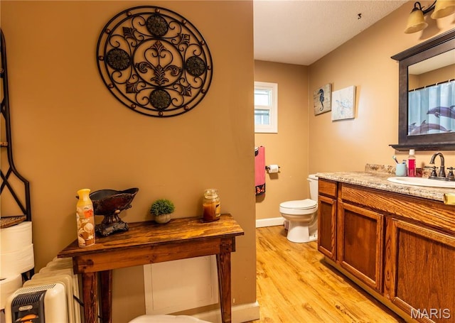 211 E Elm, Bertrand, MO 63823 - full bath featuring toilet, vanity, wood finished floors, and baseboards
