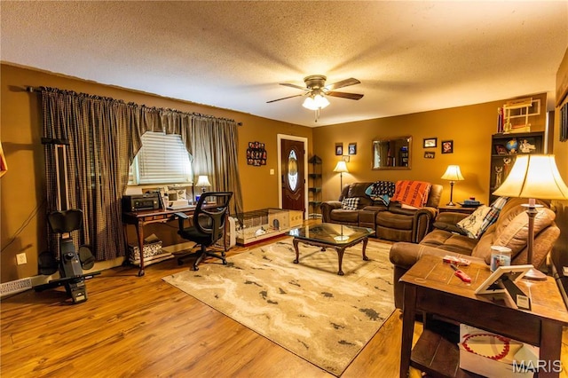 211 E Elm, Bertrand, MO 63823 - living area with ceiling fan, wood finished floors, a textured ceiling, and a desk