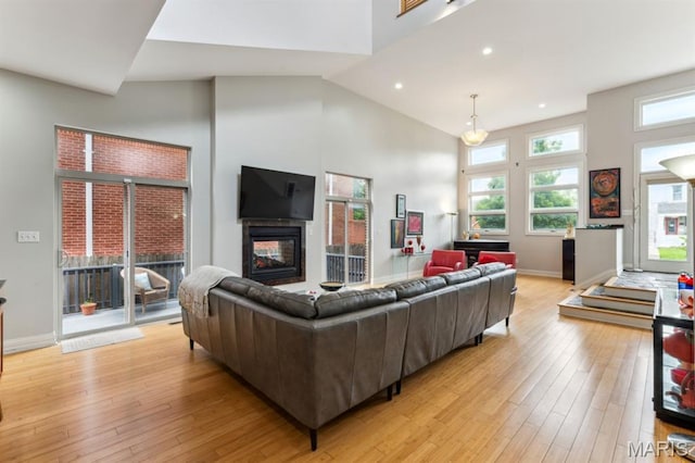 4349 Washington Blvd, Saint Louis, MO 63108 - living area with healthy amount of natural light, light wood-style flooring, a high ceiling, a multi sided fireplace, and baseboards