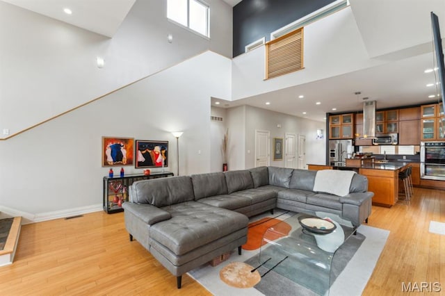 4349 Washington Blvd, Saint Louis, MO 63108 - living area with light wood-style flooring, a high ceiling, baseboards, and recessed lighting