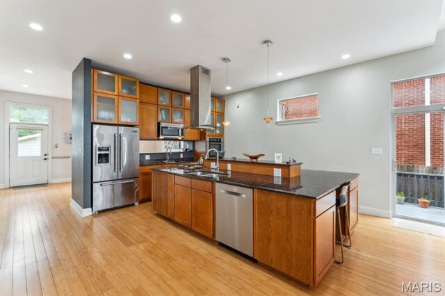 4349 Washington Blvd, Saint Louis, MO 63108 - kitchen with appliances with stainless steel finishes, island range hood, a sink, brown cabinetry, and recessed lighting