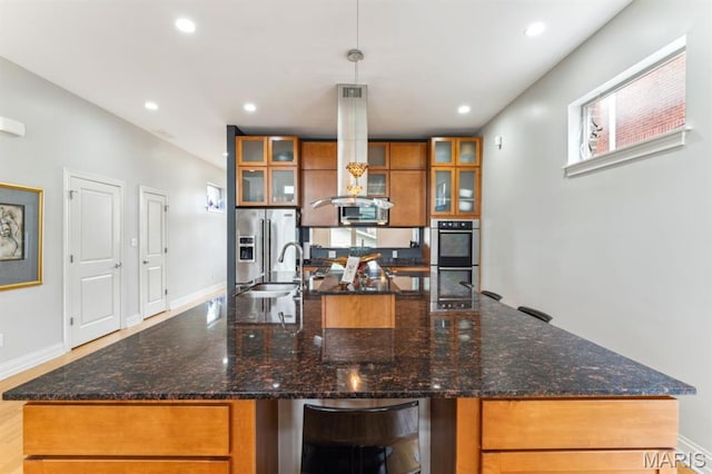 4349 Washington Blvd, Saint Louis, MO 63108 - kitchen with appliances with stainless steel finishes, brown cabinets, a sink, a spacious island, and recessed lighting