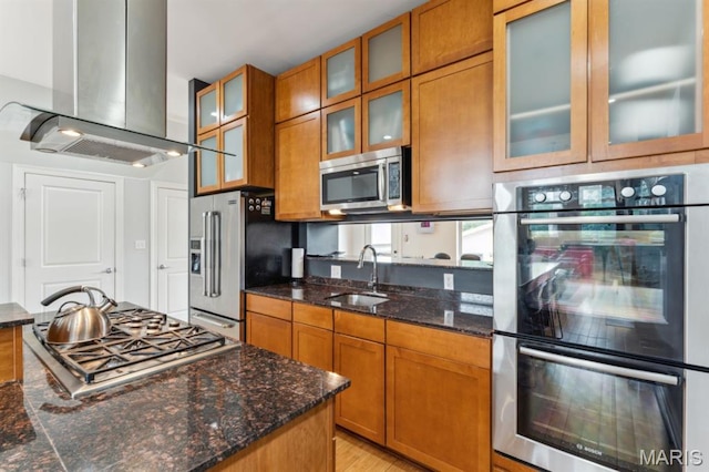 4349 Washington Blvd, Saint Louis, MO 63108 - kitchen with a sink, island exhaust hood, stainless steel appliances, brown cabinets, and dark stone countertops