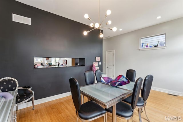 4349 Washington Blvd, Saint Louis, MO 63108 - dining area featuring wood finished floors, a chandelier, baseboards, and recessed lighting
