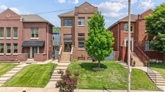 4349 Washington Blvd, Saint Louis, MO 63108 - townhome / multi-family property featuring a front lawn, stairway, and brick siding
