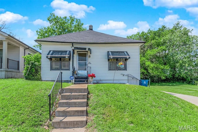 4229 Oakwood Ave, Saint Louis, MO 63121 - view of front of home with a front yard, a chimney, and roof with shingles