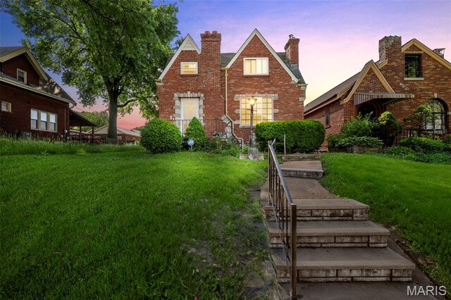 6160 Tennessee Ave, Saint Louis, MO 63111 - view of front of house featuring brick siding, a front lawn, and a chimney