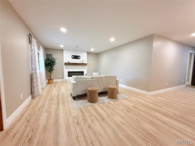 1307 Pike Dr, Bismarck, MO 63624 - unfurnished living room with light wood-type flooring, recessed lighting, a large fireplace, and baseboards
