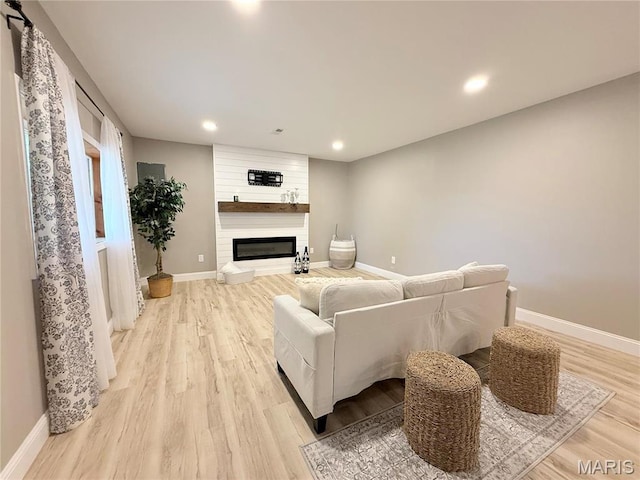 1307 Pike Dr, Bismarck, MO 63624 - living area featuring light wood-type flooring, baseboards, a large fireplace, and recessed lighting