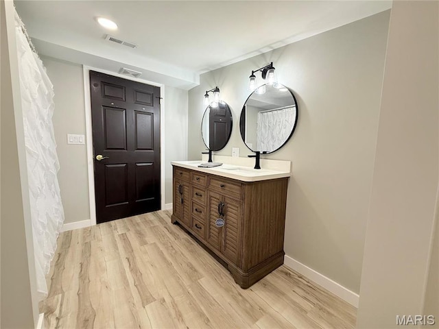 1307 Pike Dr, Bismarck, MO 63624 - bathroom featuring wood finished floors, double vanity, and baseboards