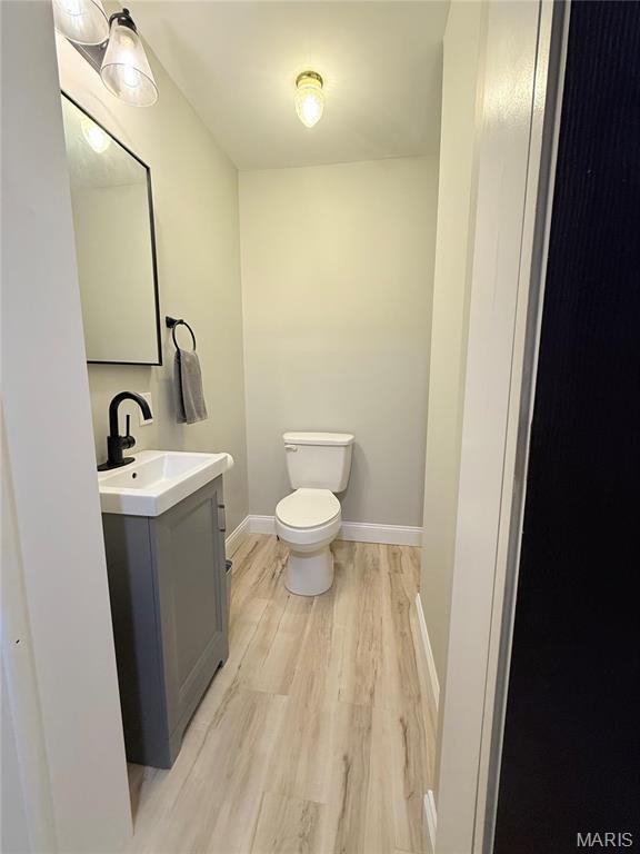 1307 Pike Dr, Bismarck, MO 63624 - bathroom featuring wood finished floors, vanity, toilet, and baseboards
