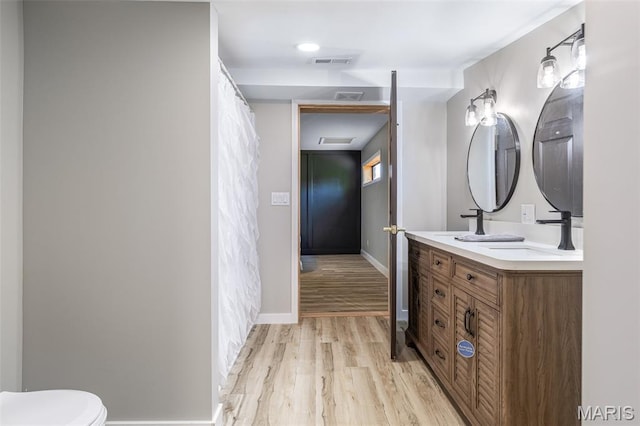 1307 Pike Dr, Bismarck, MO 63624 - full bath with wood finished floors, double vanity, baseboards, and toilet