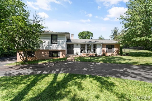 1 Woodoaks Trl, Saint Louis, MO 63124 - split level home featuring a chimney, brick siding, and asphalt driveway