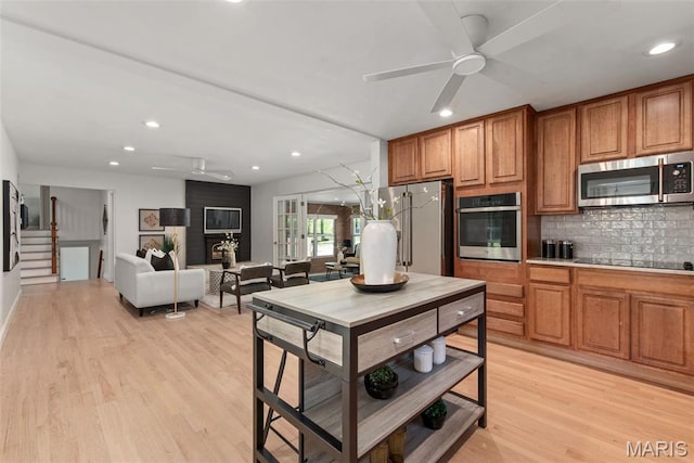 1 Woodoaks Trl, Saint Louis, MO 63124 - kitchen with appliances with stainless steel finishes, a ceiling fan, brown cabinets, tasteful backsplash, and recessed lighting