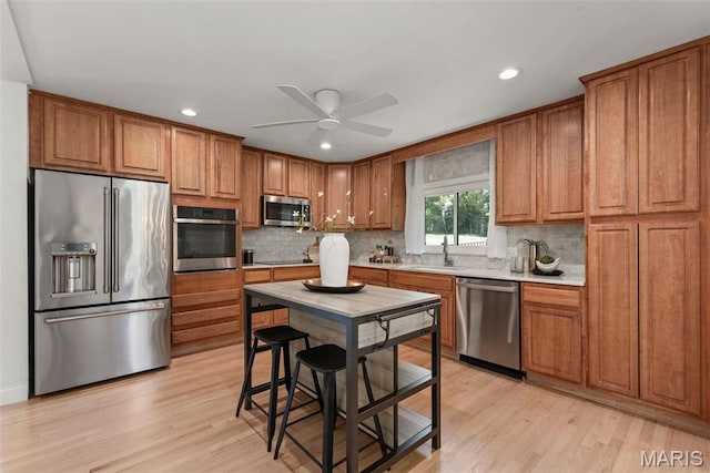 1 Woodoaks Trl, Saint Louis, MO 63124 - kitchen with appliances with stainless steel finishes, a sink, brown cabinetry, decorative backsplash, and recessed lighting
