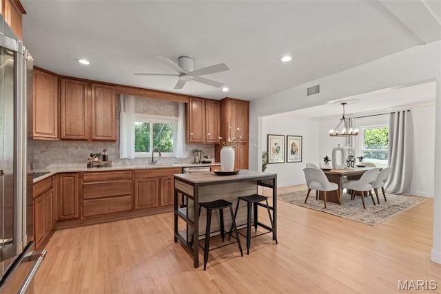1 Woodoaks Trl, Saint Louis, MO 63124 - kitchen featuring brown cabinetry, high quality fridge, tasteful backsplash, a sink, and recessed lighting