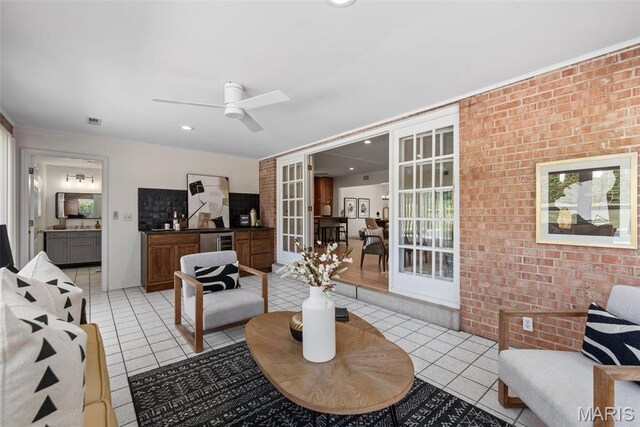 1 Woodoaks Trl, Saint Louis, MO 63124 - living room with light tile patterned floors, ceiling fan, brick wall, ornamental molding, and beverage cooler