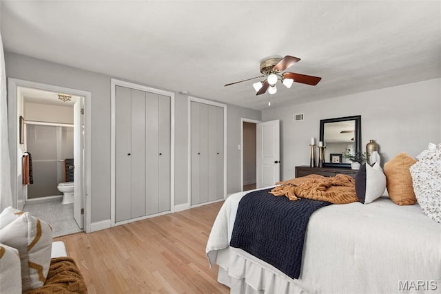1 Woodoaks Trl, Saint Louis, MO 63124 - bedroom featuring two closets, light wood finished floors, ensuite bath, baseboards, and ceiling fan