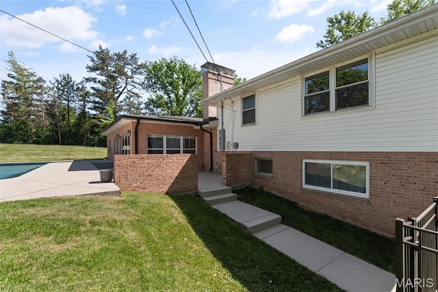 1 Woodoaks Trl, Saint Louis, MO 63124 - view of home's exterior with a yard, brick siding, a chimney, and an outdoor pool