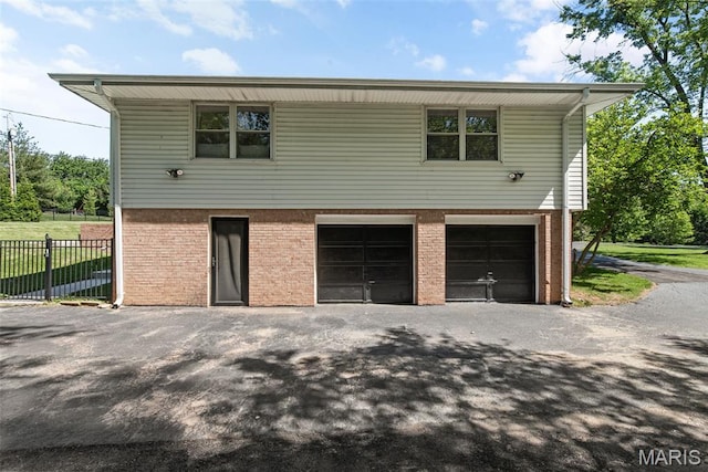 1 Woodoaks Trl, Saint Louis, MO 63124 - view of side of home with an attached garage, brick siding, and driveway