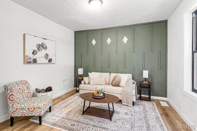 3641 Virginia Ave, Saint Louis, MO 63118 - living area featuring wood finished floors, a textured ceiling, and baseboards
