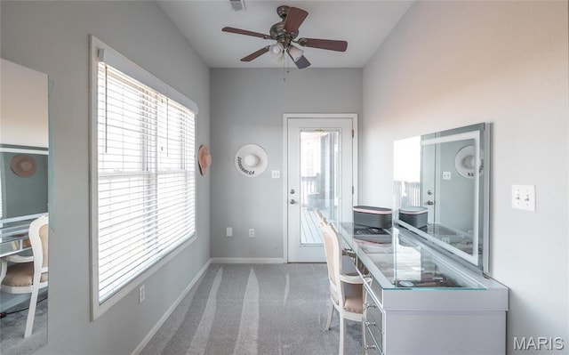 carpeted office space with plenty of natural light, a ceiling fan, and baseboards