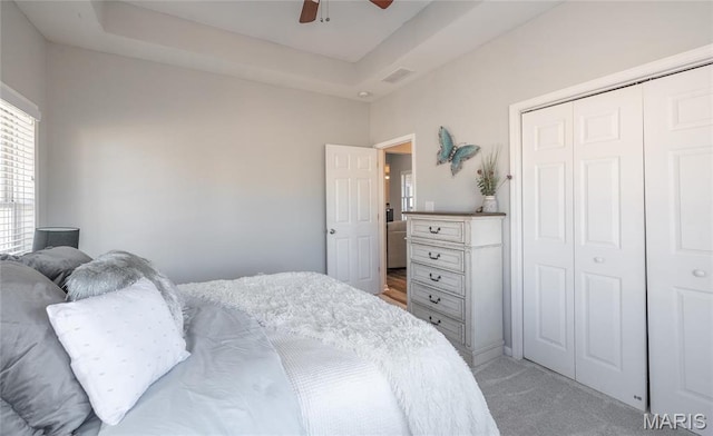 bedroom with light colored carpet, a closet, and ceiling fan