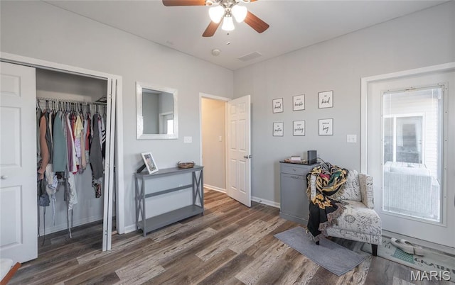 bedroom featuring wood finished floors, a closet, ceiling fan, and baseboards