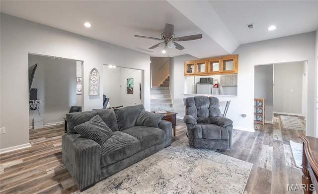 living area with stairway, a ceiling fan, wood finished floors, baseboards, and recessed lighting