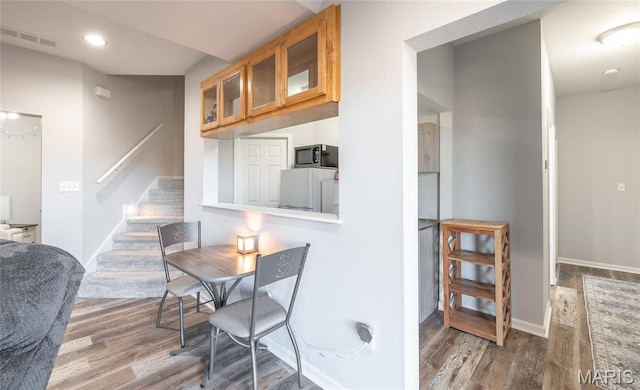 dining room featuring wood finished floors, stairs, baseboards, and recessed lighting