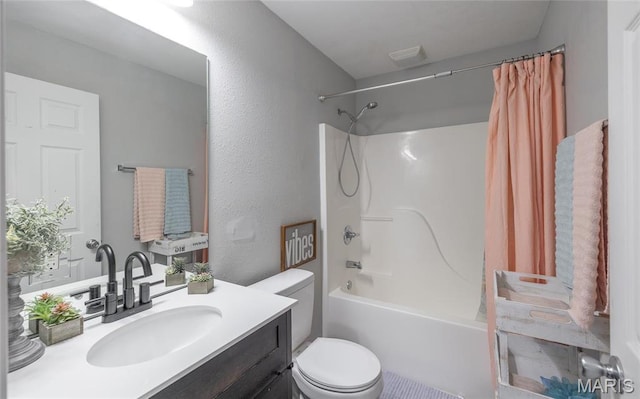bathroom with toilet, shower / bath combo with shower curtain, vanity, and a textured wall