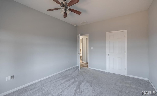 spare room featuring a ceiling fan, baseboards, and carpet flooring