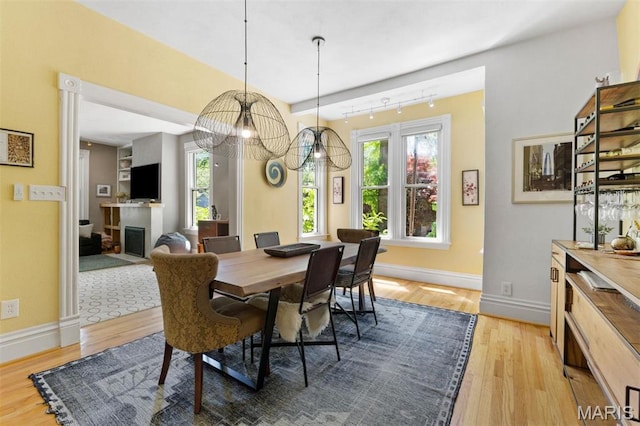dining room featuring light wood-style floors, baseboards, and a chandelier