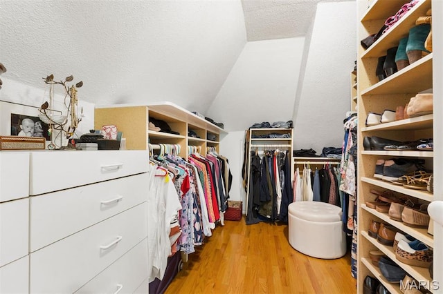 walk in closet featuring wood finished floors and lofted ceiling