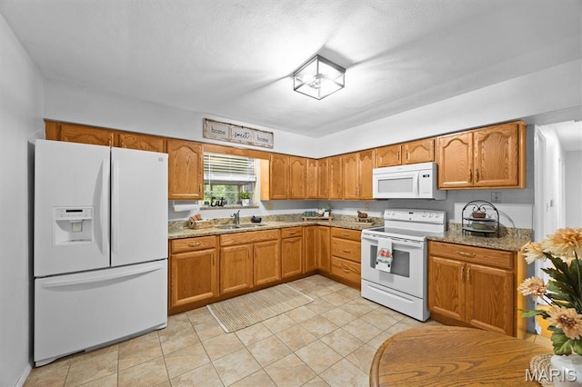 22 Briarwood Dr, Belleville, IL 62223 - kitchen with white appliances, a sink, brown cabinetry, light tile patterned floors, and light stone counters
