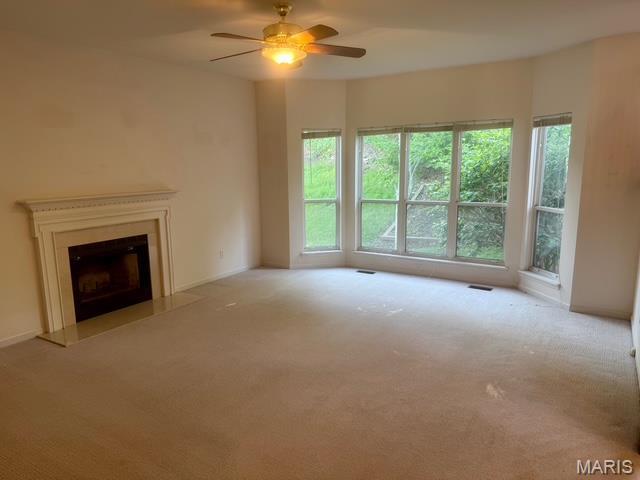 650 Legends View Dr, Eureka, MO 63025 - unfurnished living room with carpet floors, a ceiling fan, and a fireplace